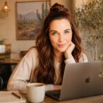 Business owner writing a helpful blog post on a laptop with notes about SEO, AI search visibility, and evergreen content in a modern home office.