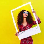 Small business owner planning a social media strategy while holding an Instagram sign creating helpful content designed to reach the right audience online.