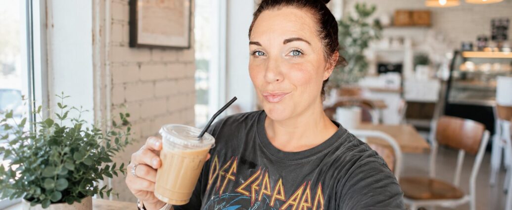 Content creator filming a video in a coffee shop while respectfully avoiding other customers and following the business's filming guidelines.