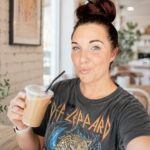Content creator filming a video in a coffee shop while respectfully avoiding other customers and following the business's filming guidelines.