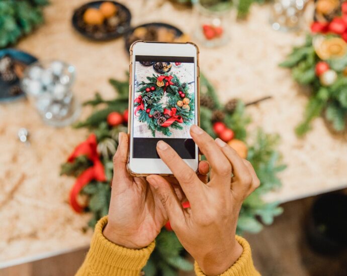 Small business owner planning holiday marketing content with a notebook, laptop, calendar, coffee, and Christmas inspiration on